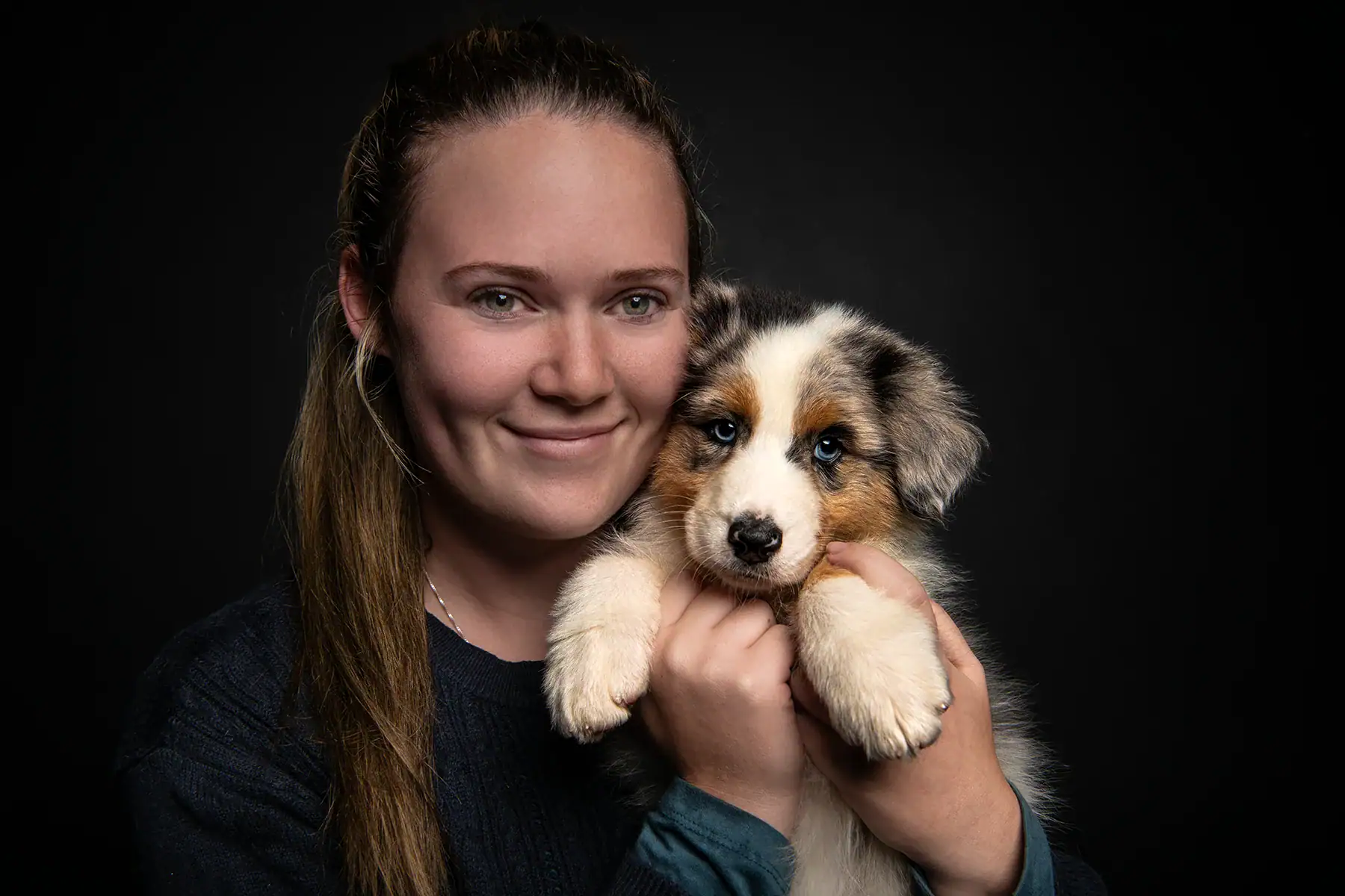 Woman holding an Australian Shepherd puppy during a pet photography session in Johannesburg