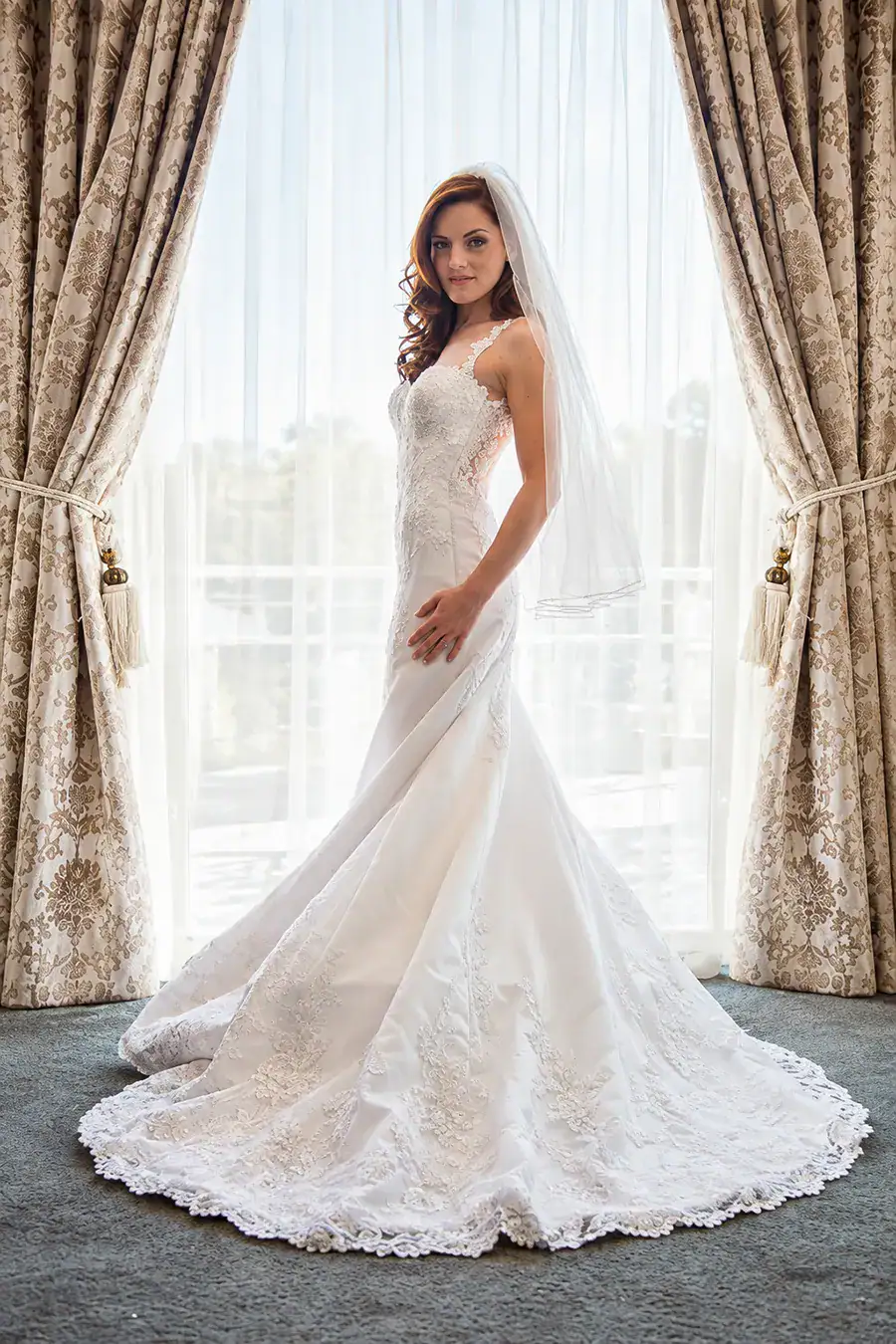 Full-length bridal portrait showing the bride's wedding dress and train