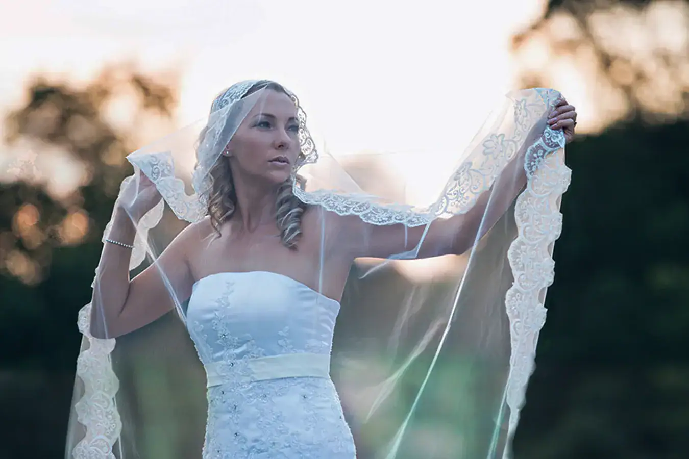Bride holding her veil during an outdoor wedding portrait