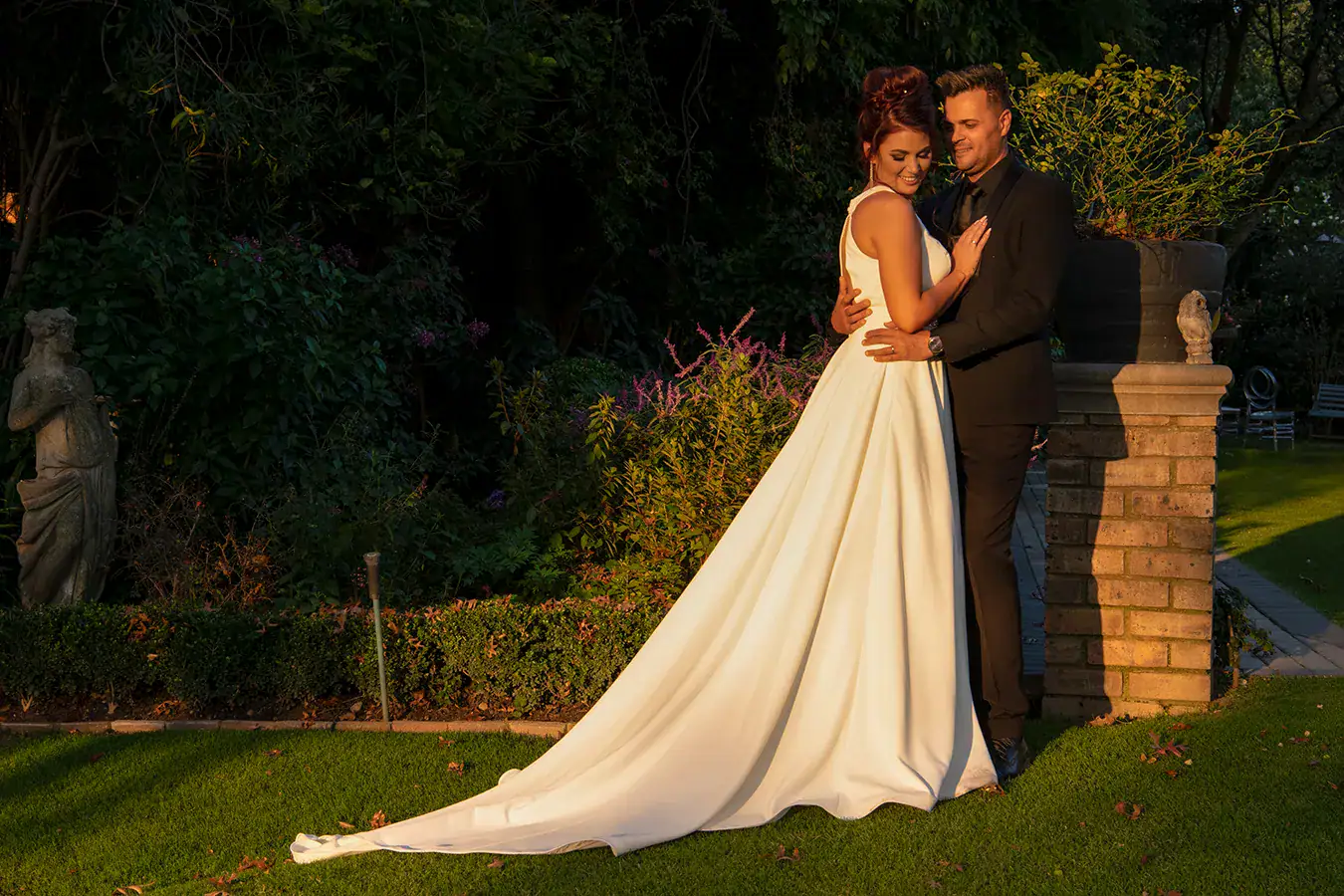 Bride and groom photographed together outdoors in evening light