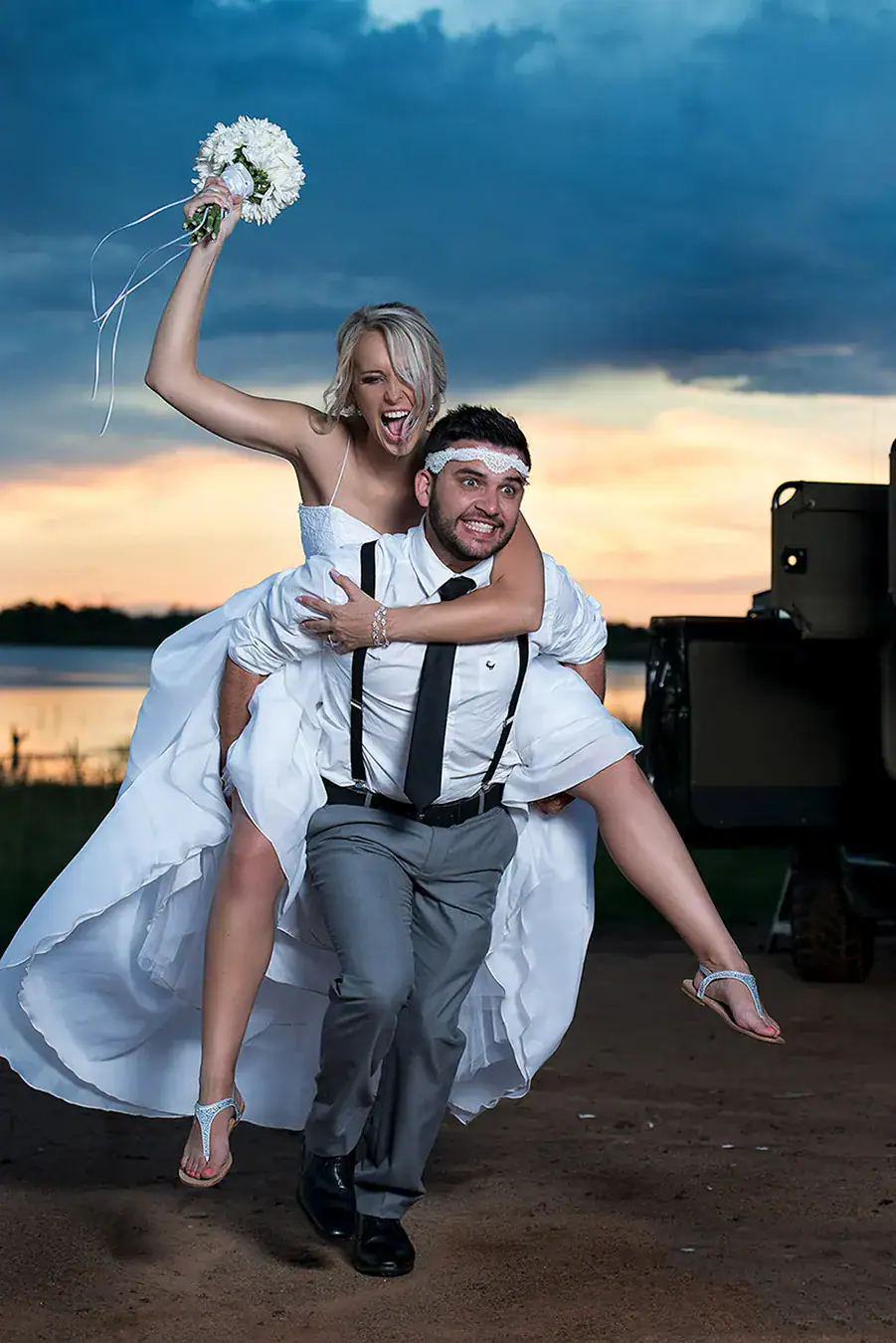 Bride riding on the groom's back during a playful wedding portrait