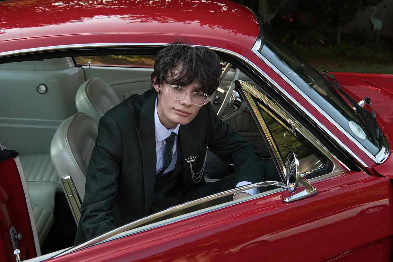 Matric farewell student in a black suit photographed with a classic red Mustang in Johannesburg