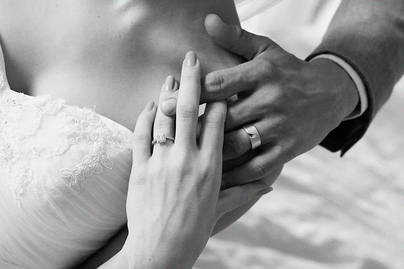 Bride and groom holding hands showing their wedding rings